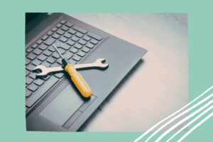 Ein Laptop, auf dem Werkzeug liegt, als Symbolbild: Die richtige Blog-Plattform finden